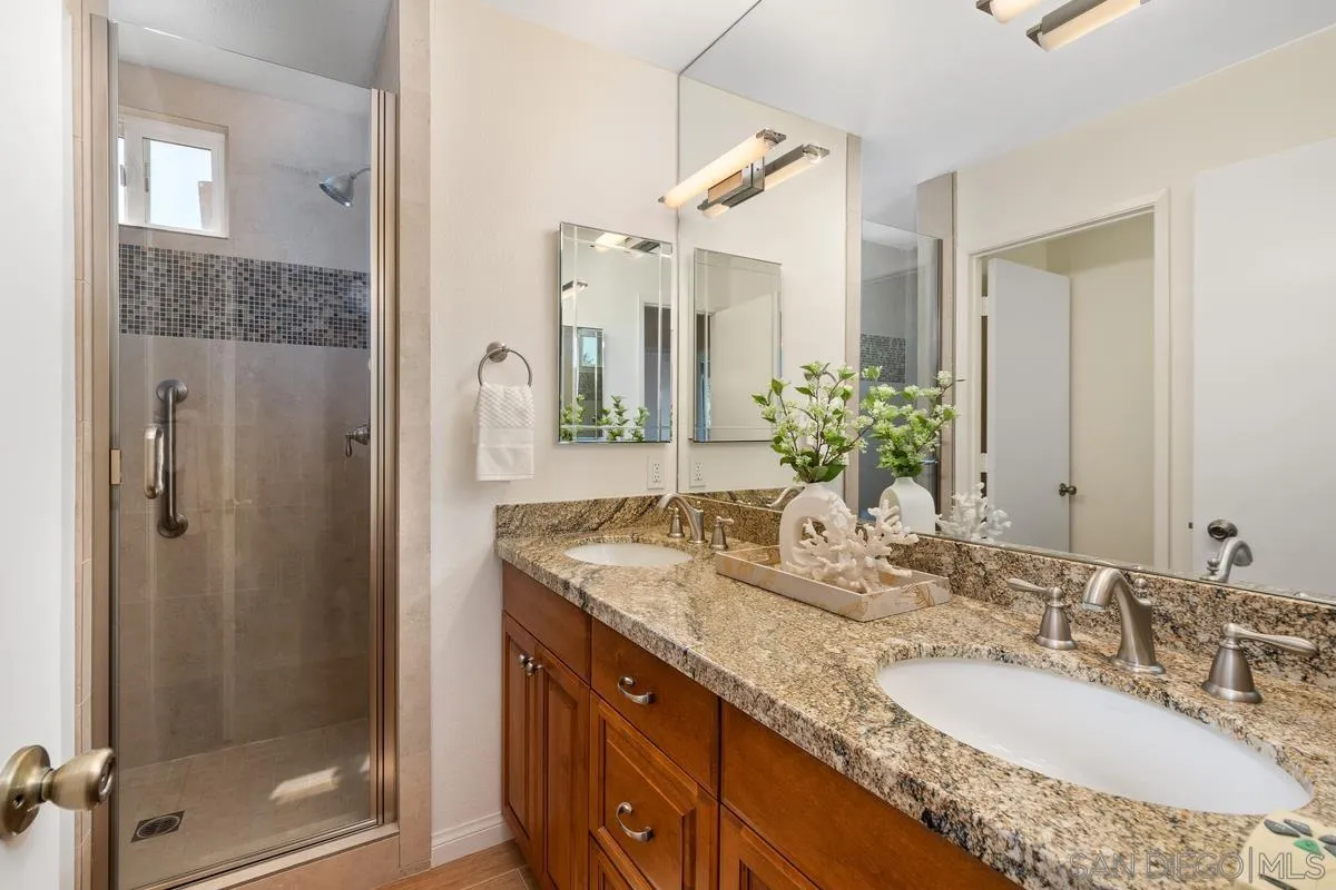 4219 Rueda Drive San Diego, CA 92124 - Photo 26 of 36 a bathroom with a granite countertop sink and a mirror