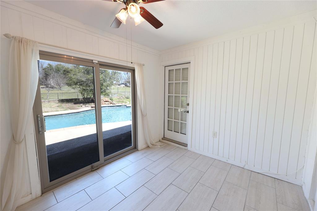 907 Red Oak Creek Road Ovilla, TX 75154 - Photo 13 of 20 Room featuring light-toned plank-style flooring, white vertical paneled walls, and a ceiling fan with integrated lighting