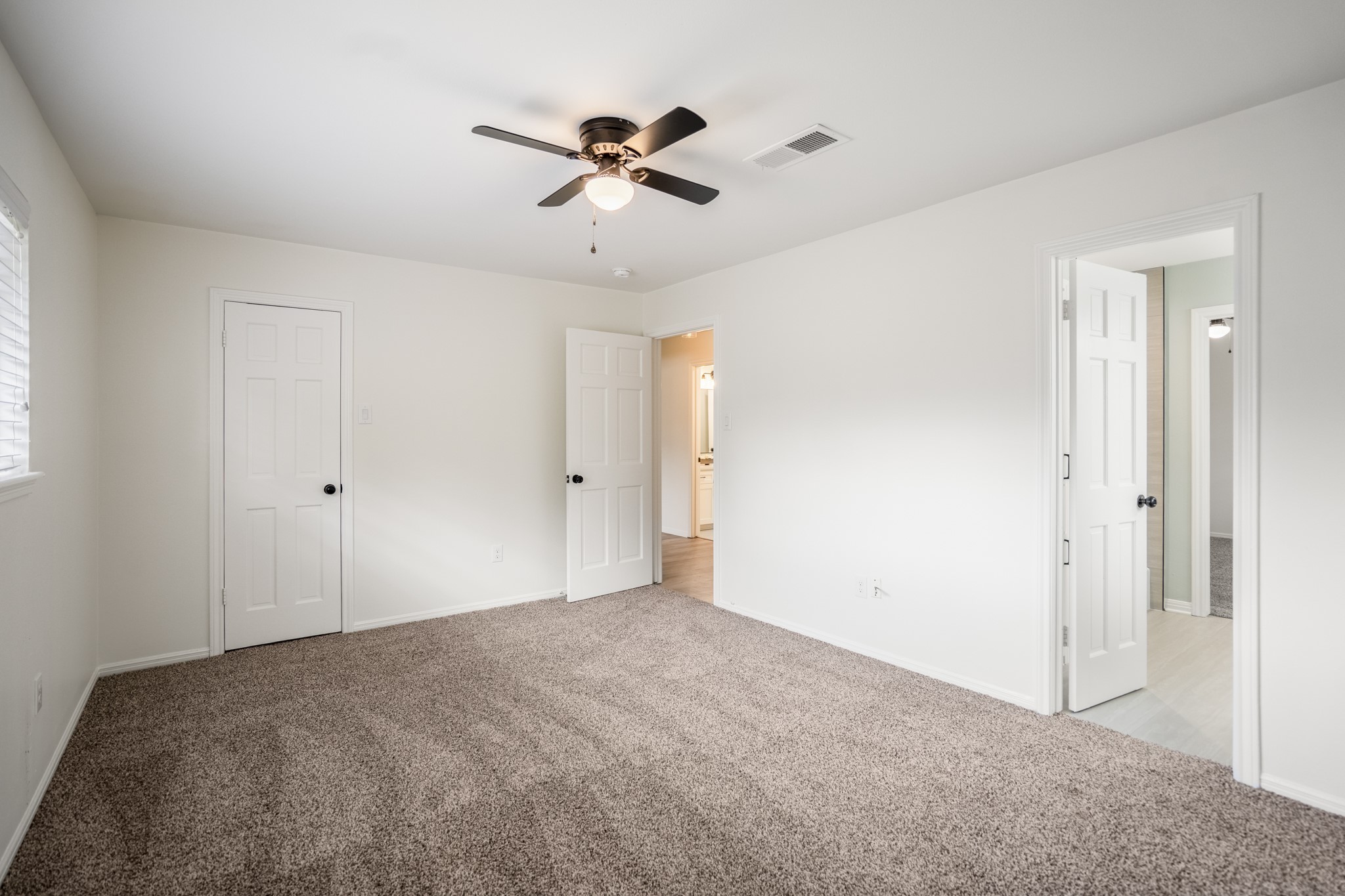 8006 Vickridge Lane Spring, TX 77379 - Photo 35 of 50 This view shows the easy access to the adjoining bathroom and hallway, along with fresh carpet and updated lighting—creating a clean, comfortable room ready for everyday use.