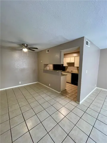 a view of a kitchen with a sink and an empty room