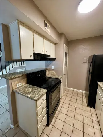 a kitchen with a stove a refrigerator and a microwave