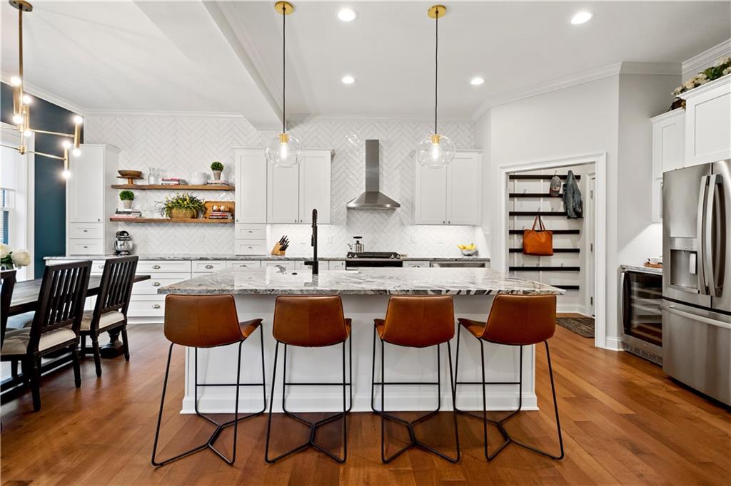 406 Silver Crest Drive Venetia, PA 15367 - Photo 3 of 25 a kitchen with stainless steel appliances granite countertop a stove a refrigerator a sink a dining table and chairs with wooden floor