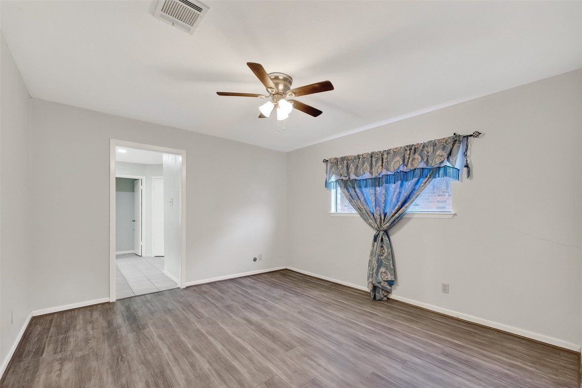 10706 Sagebluff Drive Houston, TX 77089 - Photo 11 of 19 an empty room with wooden floor and windows