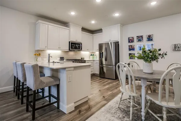 a kitchen with refrigerator a microwave and cabinets