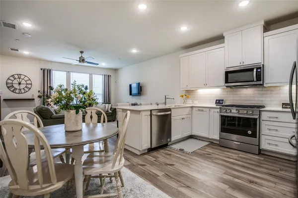 a kitchen with a table chairs microwave and cabinets