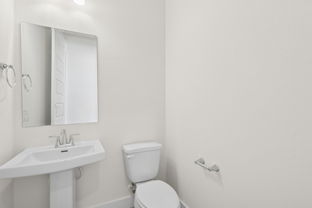 19512 Judys View Pflugerville, TX 78660 - Photo 20 of 38 a bathroom with a toilet a sink and mirror