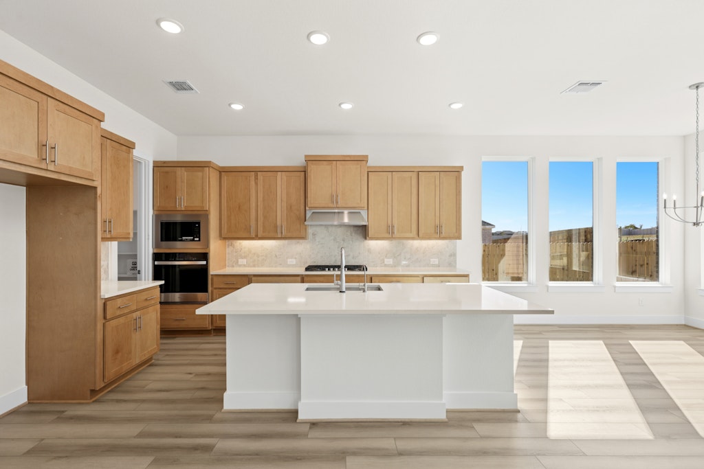 19512 Judys View Pflugerville, TX 78660 - Photo 7 of 38 a large kitchen with granite countertop a large counter top stainless steel appliances and cabinets