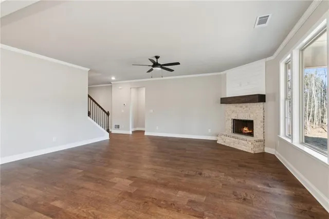 a view of an empty room with a fireplace and a window