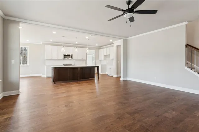 a view of empty room with wooden floor and window