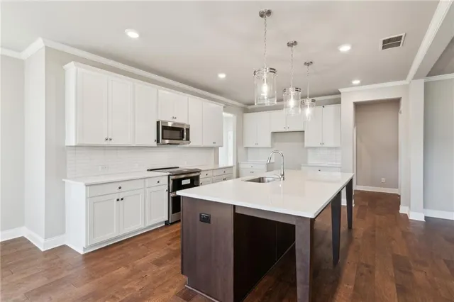 a kitchen with a sink a stove a microwave and cabinets