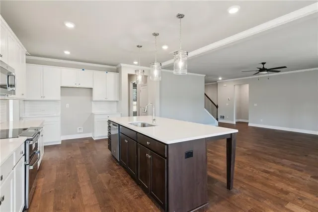 a kitchen with kitchen island a sink stove and wooden floor