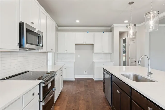 a kitchen with stainless steel appliances granite countertop a sink stove and refrigerator