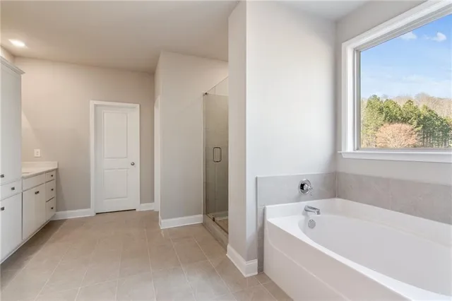 a bathroom with a tub a sink and a window