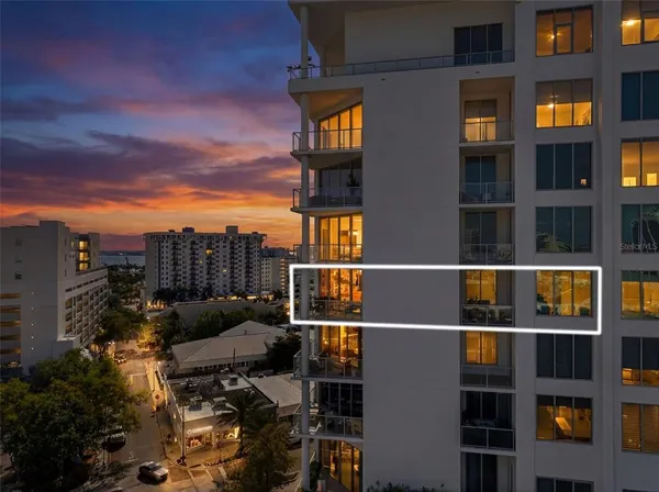 a view of a dining room with furniture a chandelier and a window
