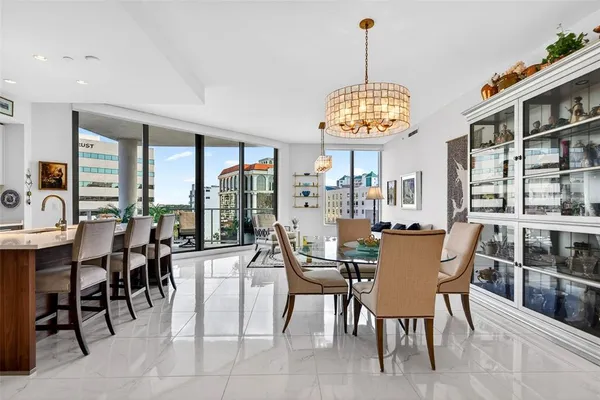 a kitchen with stainless steel appliances granite countertop a stove and a view of living room