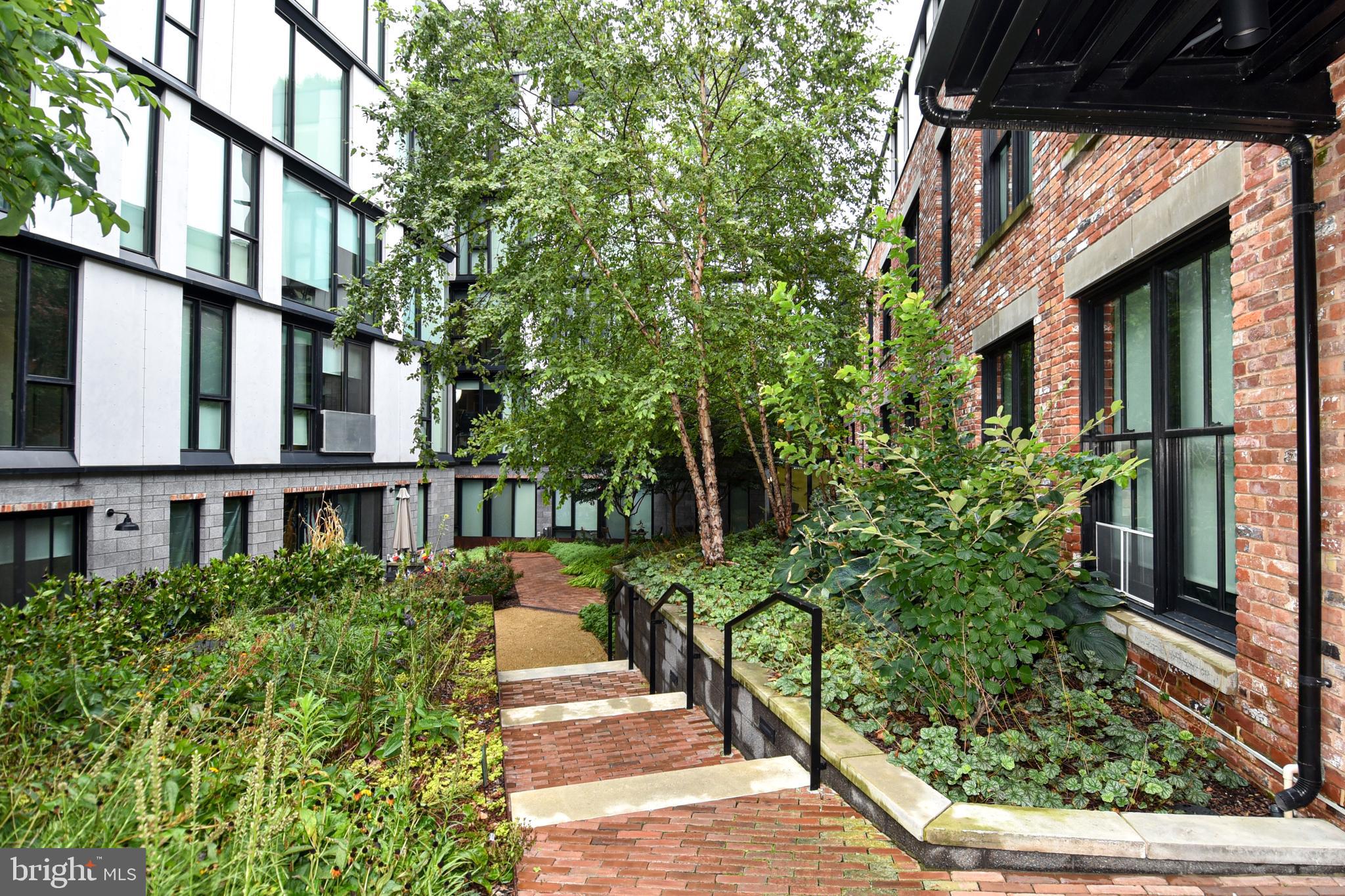 57 N Street Northwest, Unit 225 Washington, DC 20001 - Photo 27 of 38 a view of a house with a small yard and plants