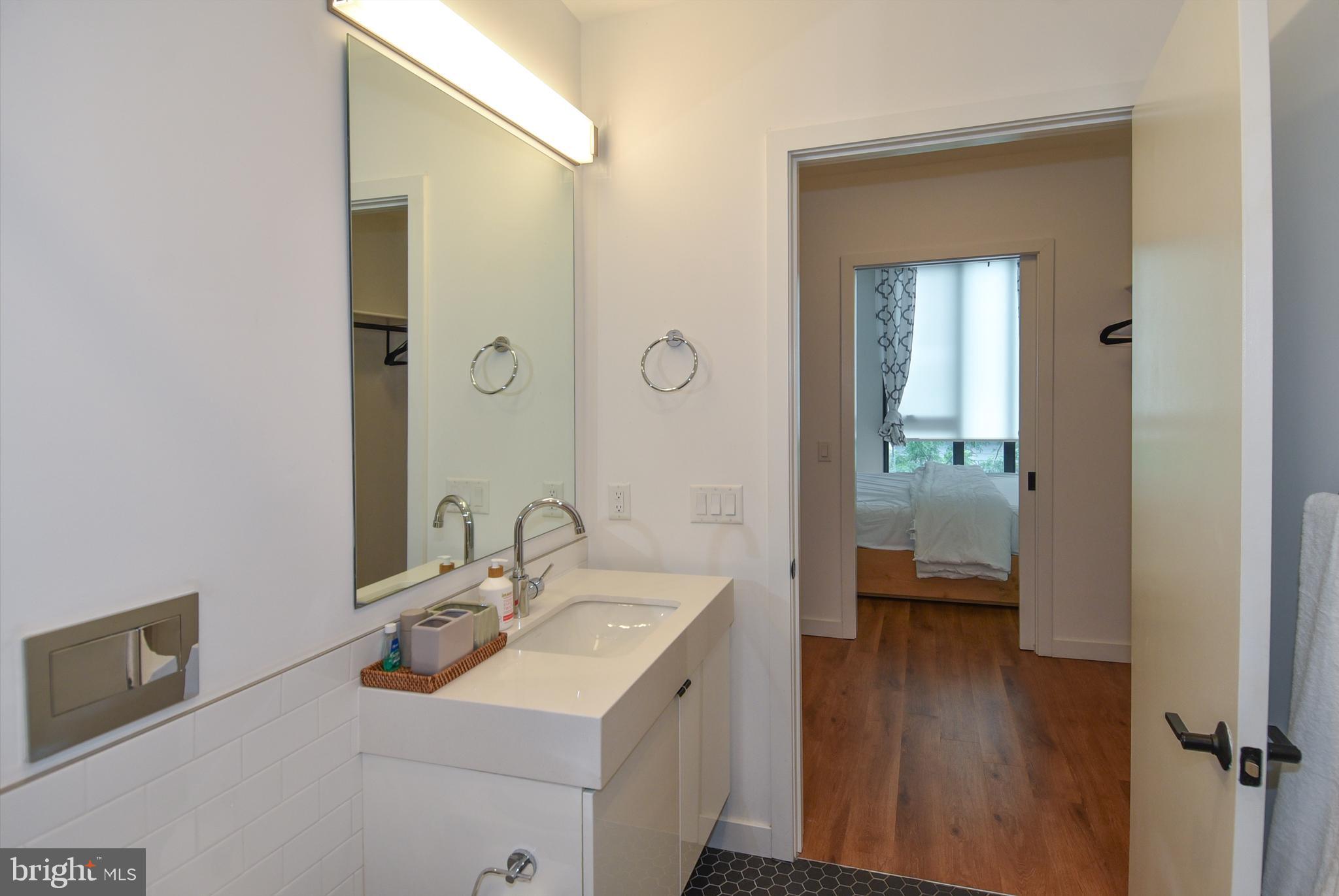 57 N Street Northwest, Unit 225 Washington, DC 20001 - Photo 9 of 38 a en suite bathroom with a sink a mirror and a shower