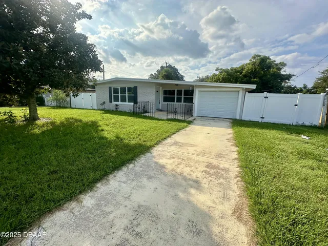 a backyard of a house with table and chairs