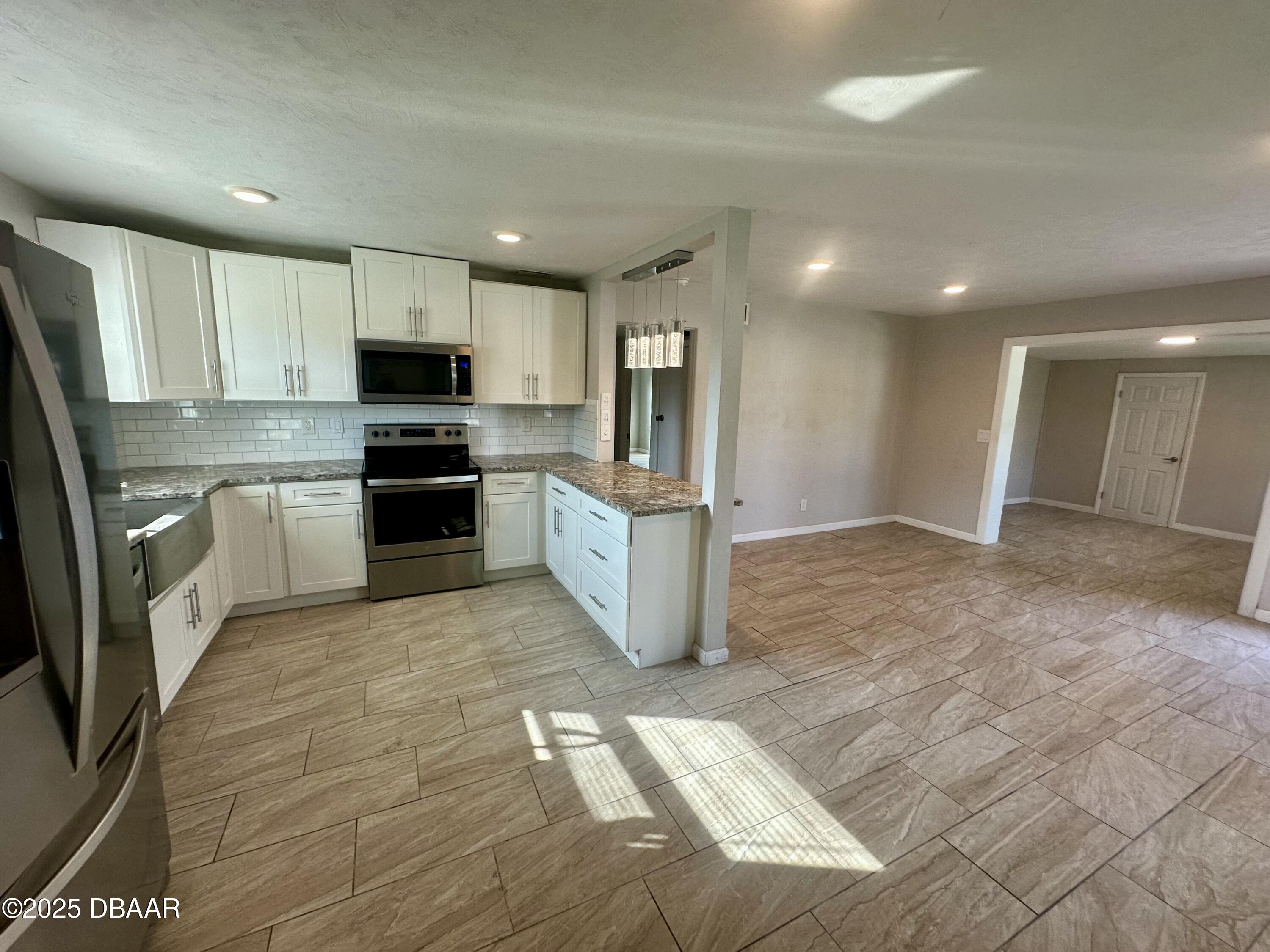 705 Largo Way South Daytona, FL 32119 - Photo 3 of 11 a kitchen with stainless steel appliances granite countertop a refrigerator sink and cabinets