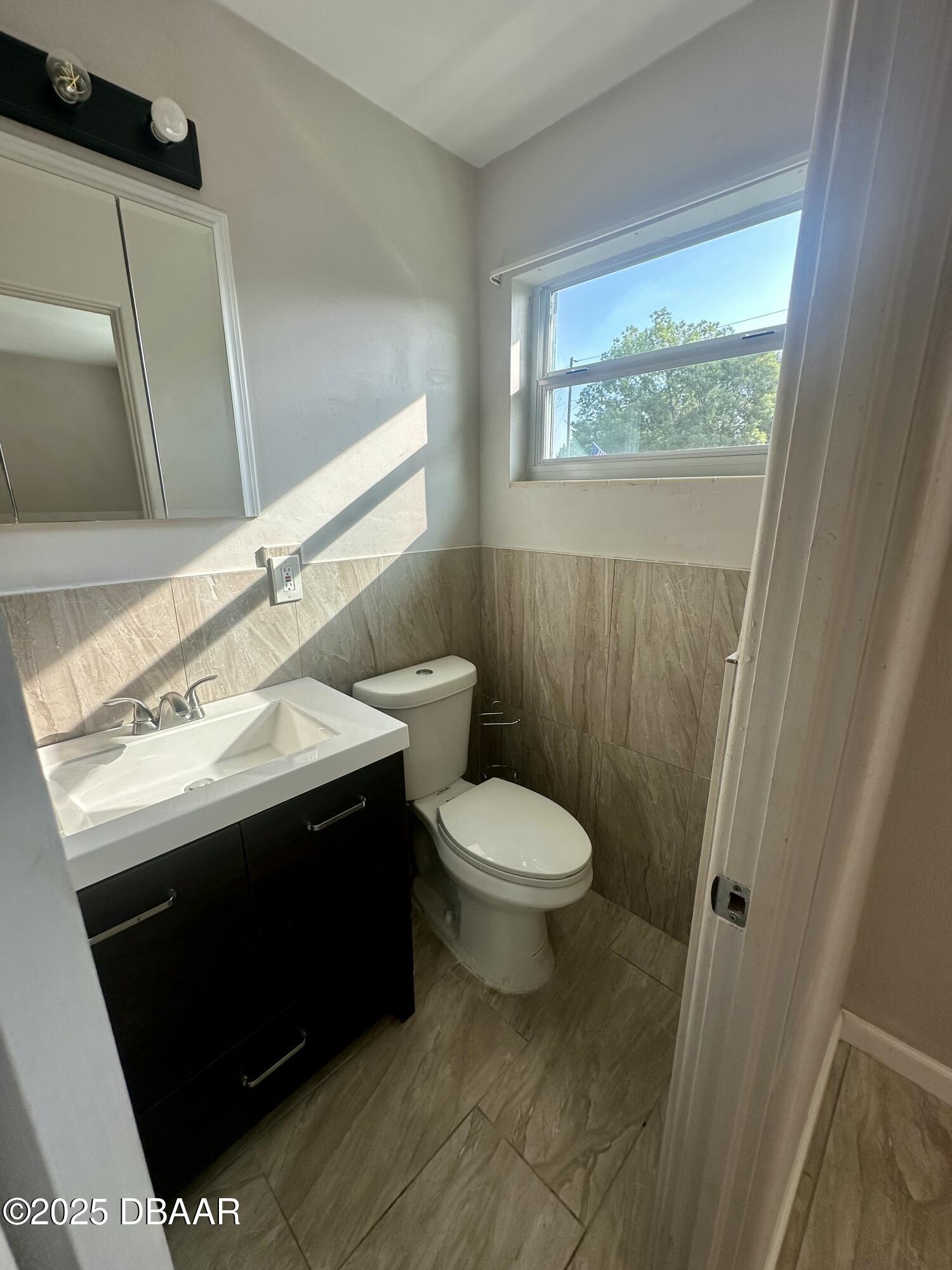 705 Largo Way South Daytona, FL 32119 - Photo 7 of 11 a bathroom with a sink a toilet and a mirror