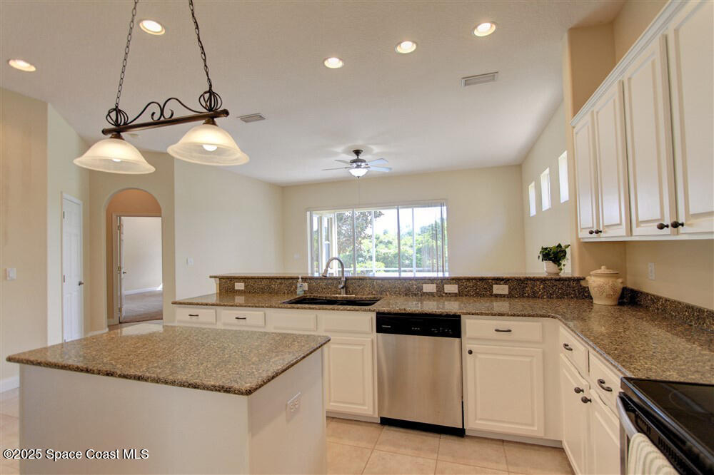 1175 Clubhouse Drive Rockledge, FL 32955 - Photo 11 of 40 a kitchen with a sink dishwasher a stove a microwave and cabinets