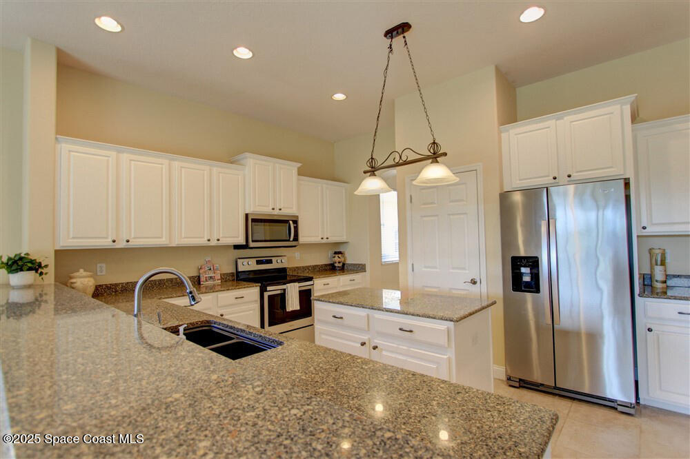 1175 Clubhouse Drive Rockledge, FL 32955 - Photo 26 of 40 a kitchen with granite countertop a sink appliances and cabinets