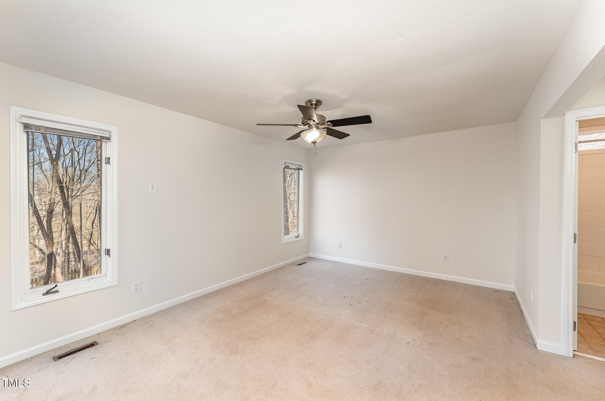 25 Sandstone Ridge Drive Durham, NC 27713 - Photo 11 of 33 an empty room with a window and a fan