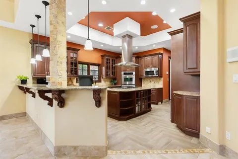 a kitchen with stainless steel appliances granite countertop a sink and a refrigerator