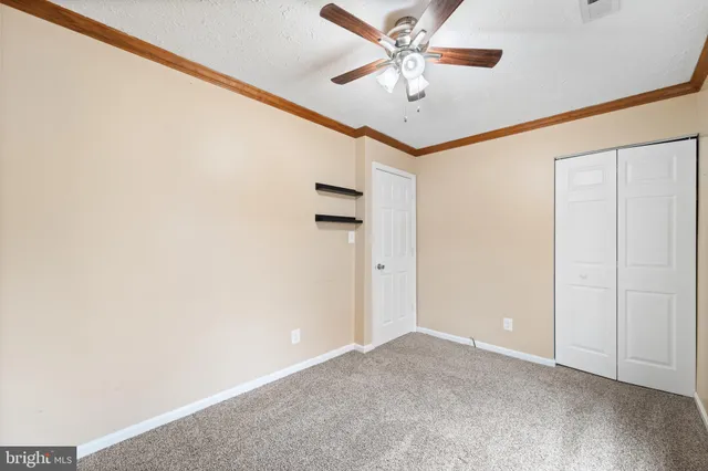 an empty room with a ceiling fan and wooden floor