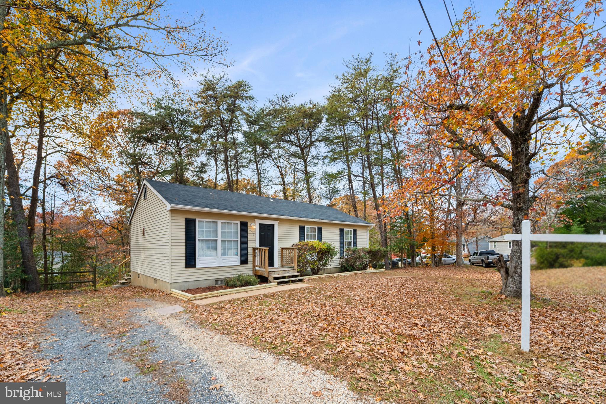 659 San Gabriel Road Lusby, MD 20657 - Photo 4 of 20 a view of a white house next to a yard with large trees