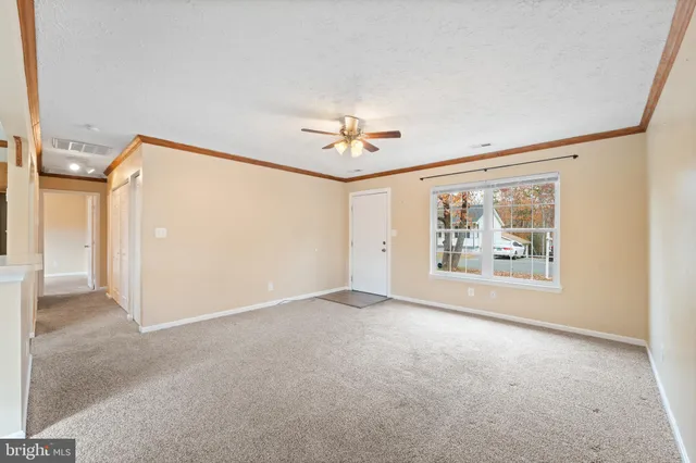 an empty room with fan and windows