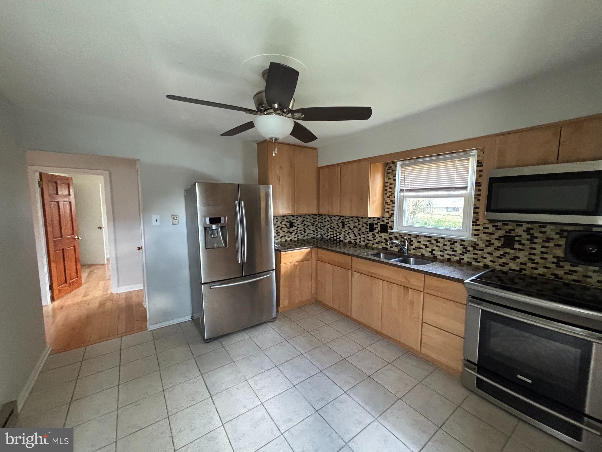 a kitchen with stainless steel appliances granite countertop a refrigerator and a stove top oven