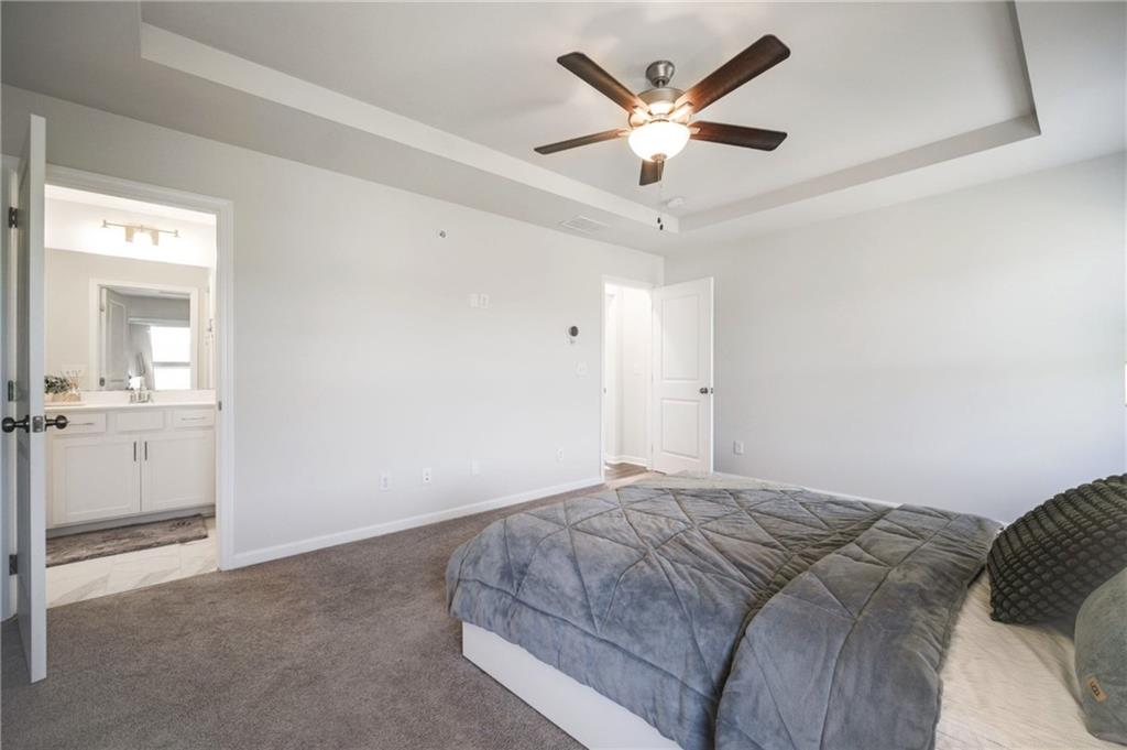 1595 Ridgebrook Downs Mableton, GA 30126 - Photo 20 of 39 a bedroom with a large bed and a chandelier