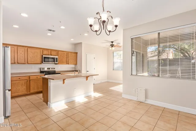 a kitchen with stainless steel appliances granite countertop a refrigerator a sink dishwasher a stove and white cabinets with wooden floor