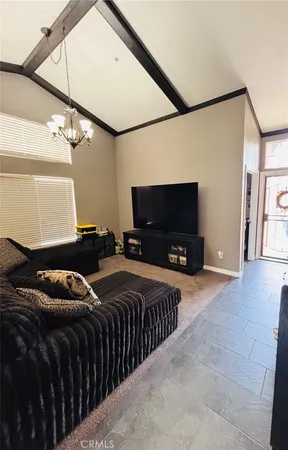 a living room with stainless steel appliances furniture and kitchen view