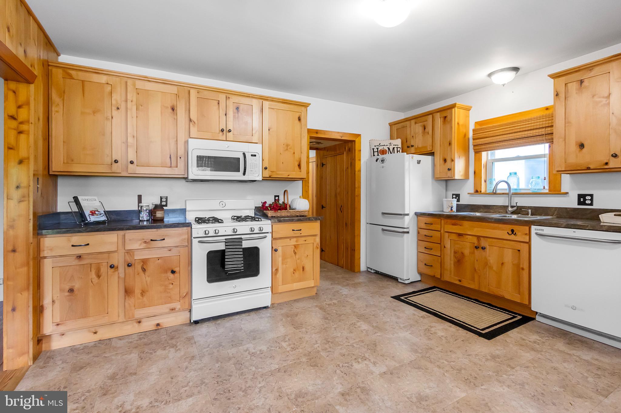2485 Potomac Road Berkeley Springs, WV 25411 - Photo 14 of 60 a kitchen with stainless steel appliances white cabinets and a stove top oven