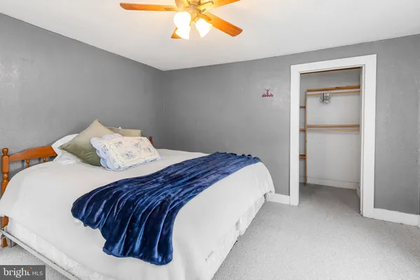 a bedroom with a bed and a ceiling fan