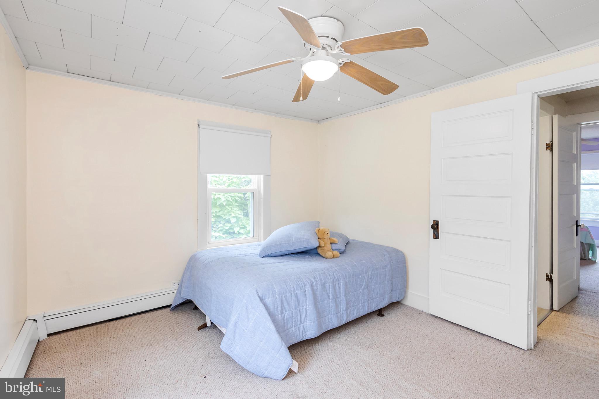 2485 Potomac Road Berkeley Springs, WV 25411 - Photo 38 of 60 a bedroom with a bed and a ceiling fan