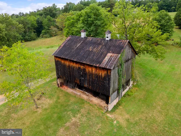 a kitchen with stainless steel appliances granite countertop a stove top oven a sink a dining table and chairs with wooden floor