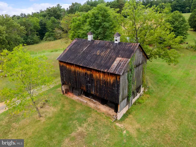 a kitchen with stainless steel appliances granite countertop a stove top oven a sink a dining table and chairs with wooden floor