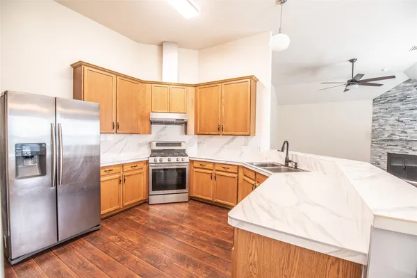 a kitchen with stainless steel appliances granite countertop a sink stove and refrigerator