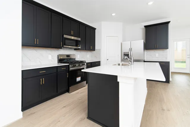 a kitchen with stainless steel appliances granite countertop a sink stove and microwave