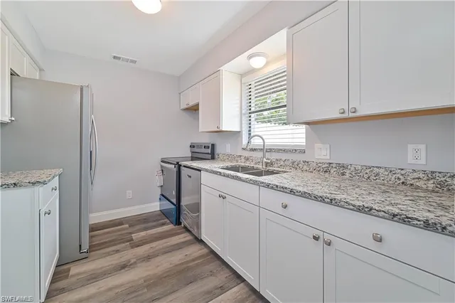 a kitchen with granite countertop white cabinets and white appliances