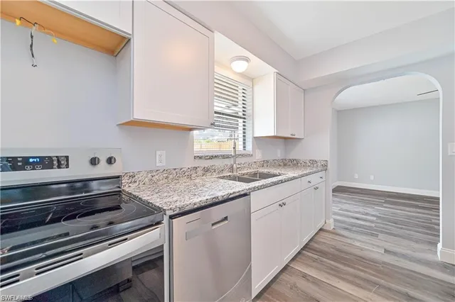a kitchen with granite countertop a stove and a sink
