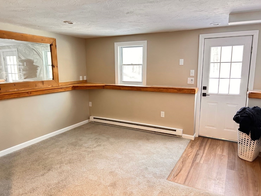 109 Blackstone Street, Unit 109 Bellingham, MA 02019 - Photo 13 of 15 an empty room with wooden floor and windows