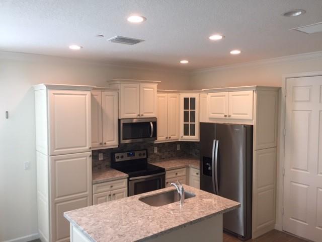 14377 Sims Road, Unit 14420 Delray Beach, FL 33484 - Photo 3 of 5 a kitchen with a refrigerator a microwave a sink and a stove