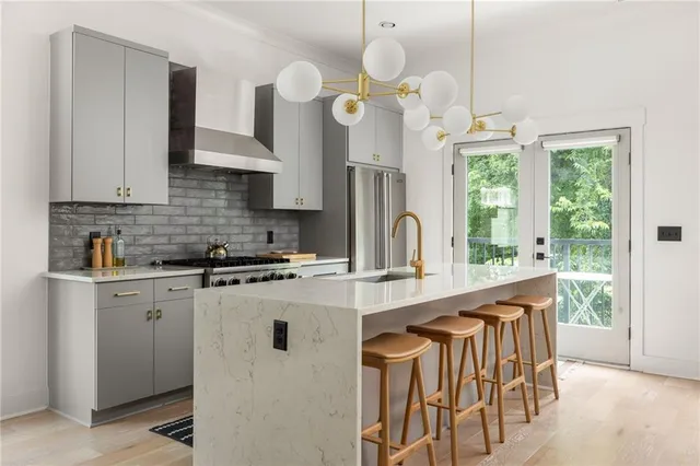 a kitchen with stainless steel appliances granite countertop a sink a stove and a refrigerator