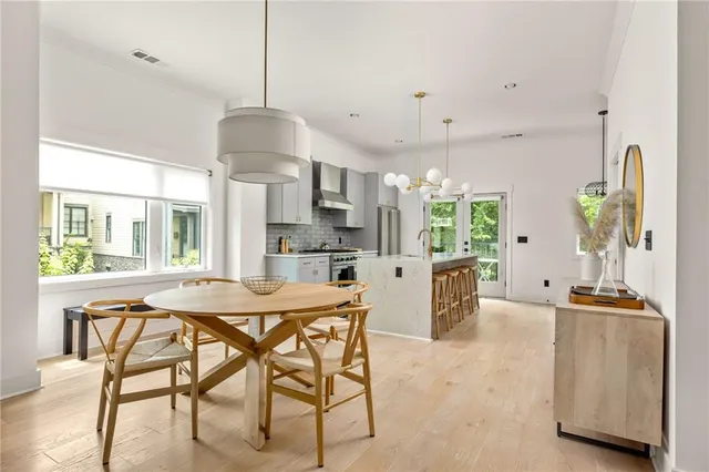 a view of a dining room and livingroom with furniture wooden floor a chandelier