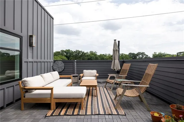 an outdoor sitting area with furniture and umbrella
