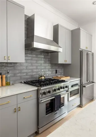 a kitchen with stainless steel appliances white cabinets and a stove top oven
